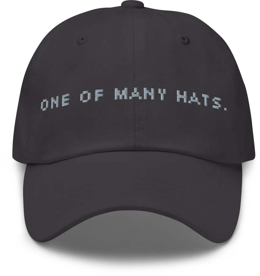 Dark grey dad hat embroidered with ONE OF MANY HATS.