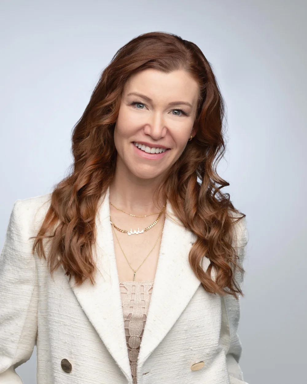 Megan Brittain Adams, founder of ShortRunway.Co, smiling in a cream blazer